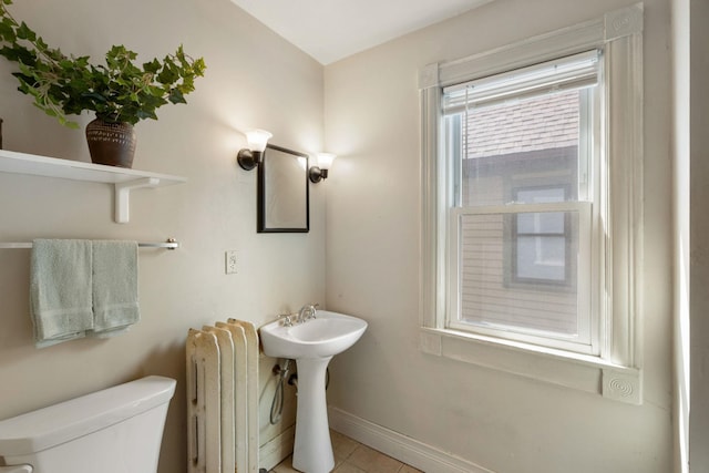 709 7th St SE, Minneapolis, MN 55414 - half bathroom featuring radiator heating unit, toilet, tile patterned floors, and baseboards