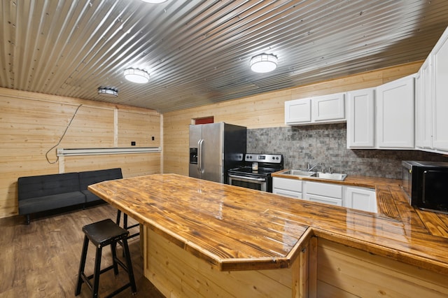 24625 Fosmo Dr, La Follette Twp, WI 54893 - kitchen featuring wood counters, appliances with stainless steel finishes, a sink, white cabinets, and a kitchen bar