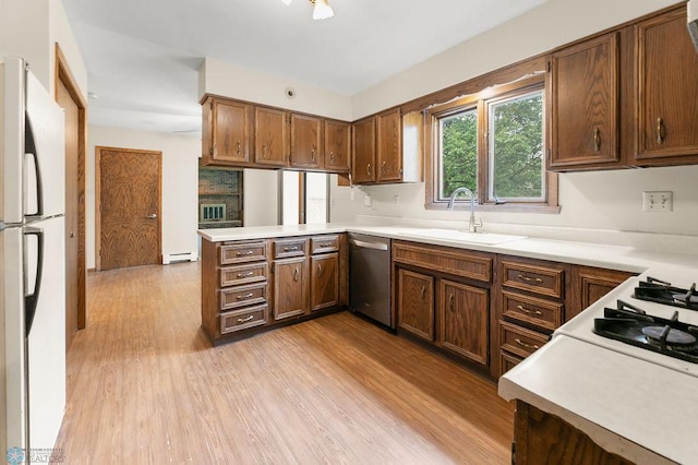 3667 Evergreen Rd N, Fargo, ND 58102 - kitchen with stainless steel dishwasher, freestanding refrigerator, a sink, light wood-type flooring, and a peninsula