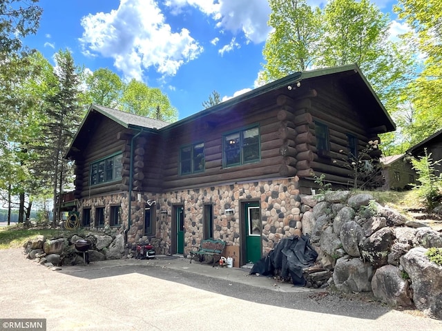 view of front of property with log siding and stone siding