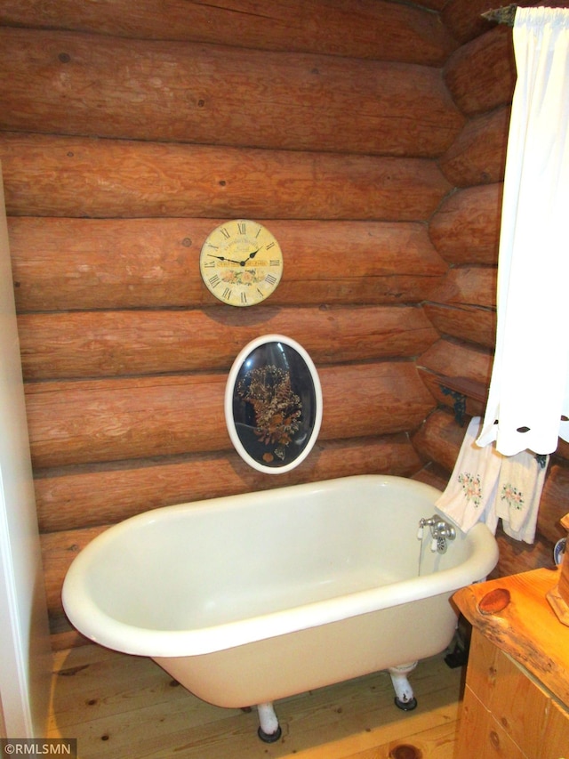 bathroom featuring a soaking tub and wood finished floors