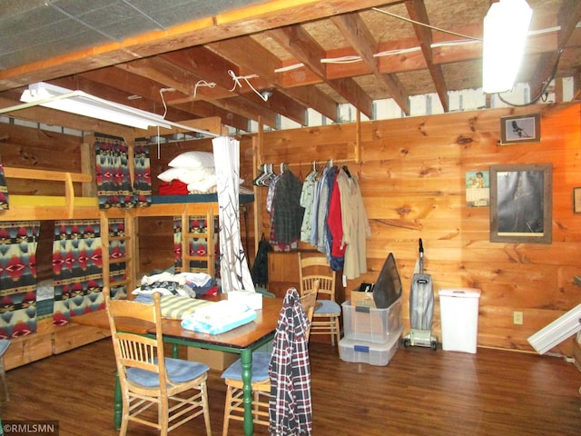 dining room with wood finished floors and wooden walls