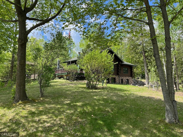 view of green lawn with a wooden deck