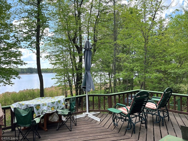wooden deck featuring outdoor dining area and a water view