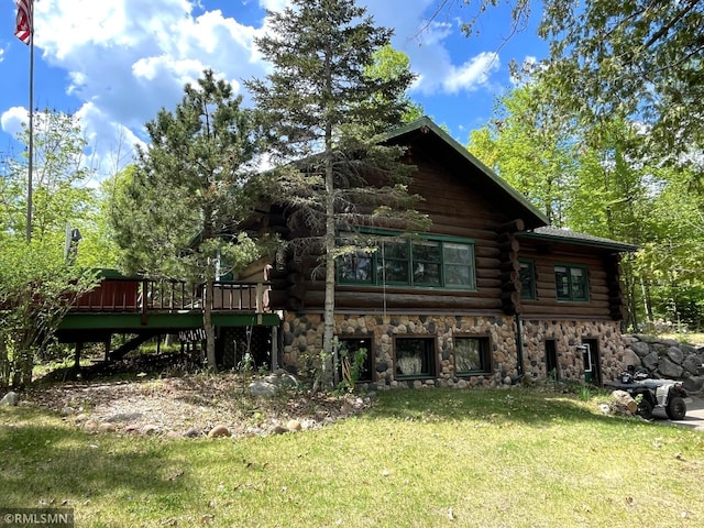 back of property featuring log siding, a yard, a wooden deck, and stone siding
