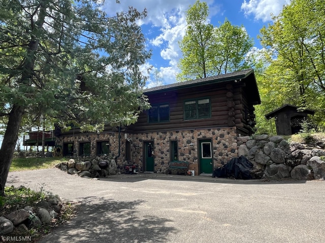 view of front of property featuring log exterior and stone siding