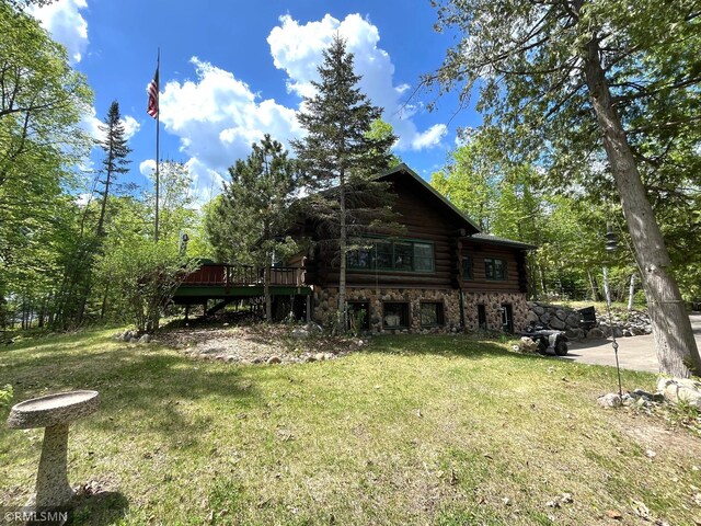 4701 Shangri La Dr NE, Wabedo Twp, MN 56655 - rear view of house featuring log siding, a lawn, a wooden deck, and stone siding