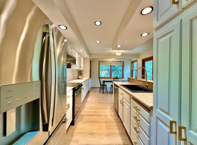 kitchen featuring appliances with stainless steel finishes, a sink, recessed lighting, light countertops, and decorative backsplash