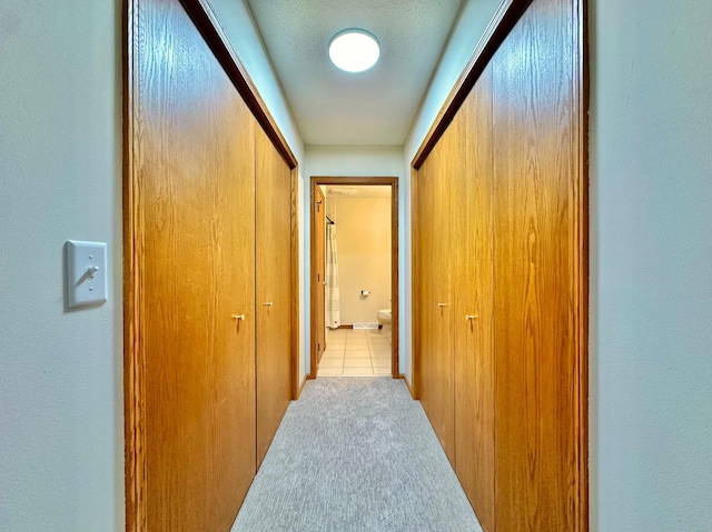 hall featuring carpet and tile patterned flooring