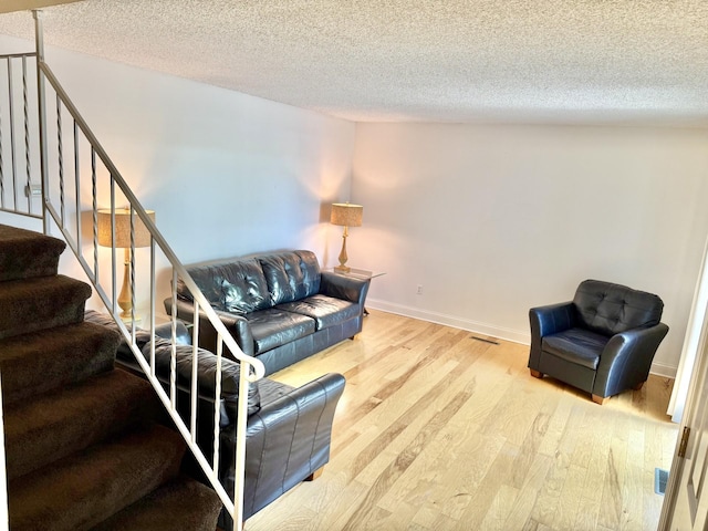 3568 Cloman Way, Inver Grove Heights, MN 55076 - living area with a textured ceiling, wood finished floors, stairway, and baseboards