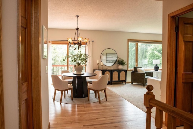 2505 Christian Dr, Chaska, MN 55318 - dining room with a chandelier, light wood-style floors, a textured ceiling, and baseboards