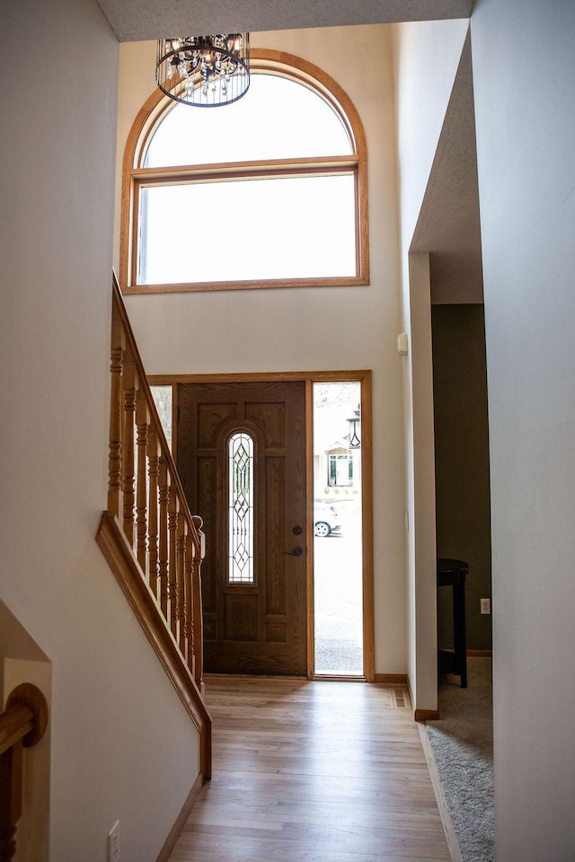 2505 Christian Dr, Chaska, MN 55318 - foyer with a high ceiling, a chandelier, healthy amount of natural light, wood finished floors, and stairway