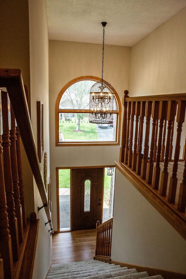 2505 Christian Dr, Chaska, MN 55318 - foyer entrance with wood finished floors, stairway, a chandelier, and a textured ceiling