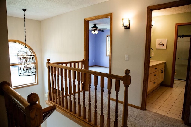2505 Christian Dr, Chaska, MN 55318 - staircase with a chandelier, ceiling fan, carpet, tile patterned flooring, and a textured ceiling