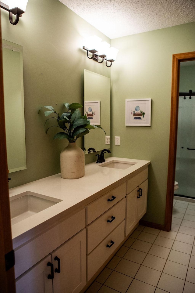 2505 Christian Dr, Chaska, MN 55318 - bathroom featuring double vanity, a textured ceiling, tile patterned flooring, toilet, and a shower