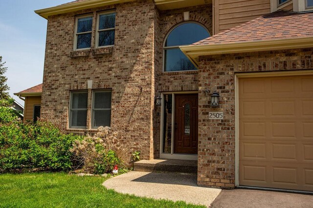 2505 Christian Dr, Chaska, MN 55318 - view of exterior entry featuring a garage and roof with shingles