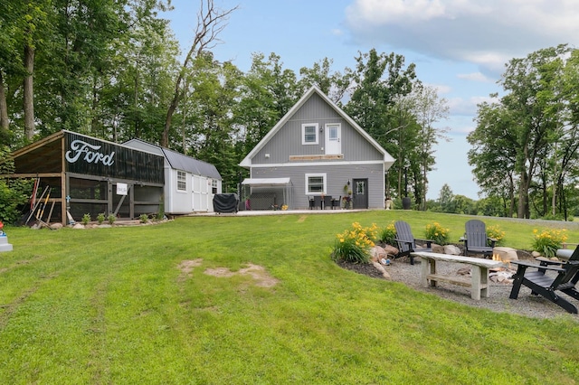 2293 57th Ave, East Farmington, WI 54020 - back of house featuring a fire pit, a lawn, and an outdoor structure