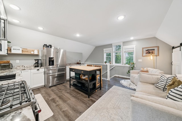 2293 57th Ave, East Farmington, WI 54020 - kitchen featuring stainless steel appliances, vaulted ceiling, white cabinetry, dark wood-style floors, and light stone counters