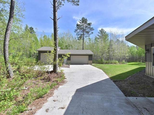 33272 Big Pine Trl, Grand Rapids, MN 55744 - exterior space with concrete driveway, a lawn, an attached garage, and a wooded view
