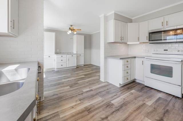 30105 Olinda Trl, Lindstrom, MN 55045 - kitchen featuring stainless steel microwave, white range with electric cooktop, crown molding, light wood-type flooring, and white cabinetry