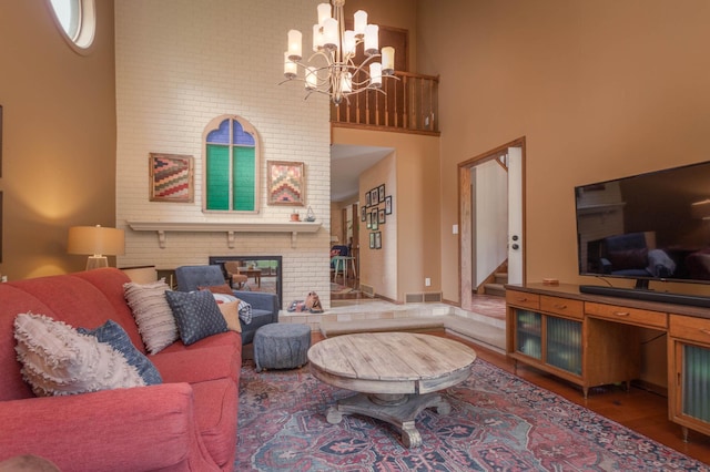 1108 Maple St, Alexandria, MN 56308 - living room with a fireplace, a chandelier, stairs, a high ceiling, and wood finished floors