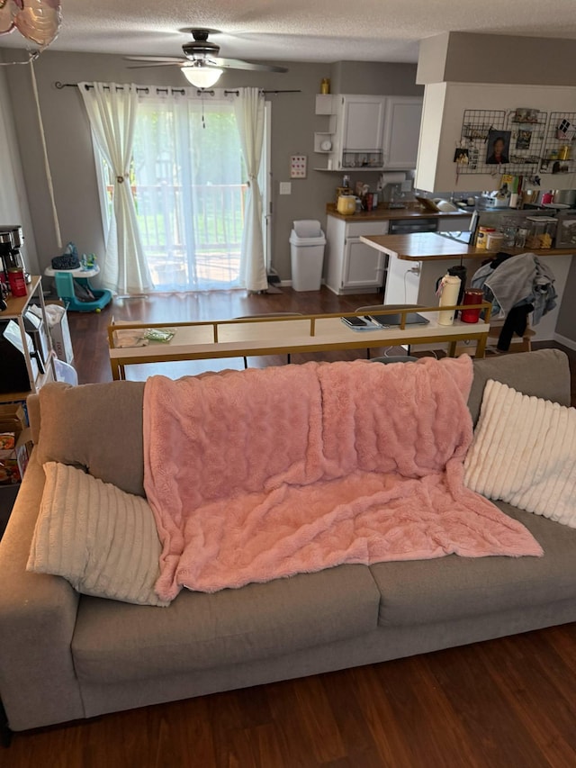 living area with wood finished floors, ceiling fan, and a textured ceiling