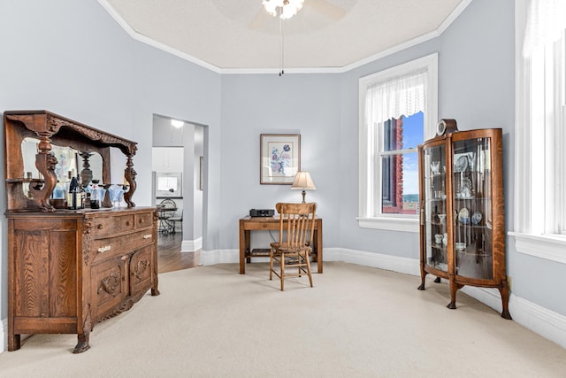 carpeted office with ornamental molding, a ceiling fan, and baseboards