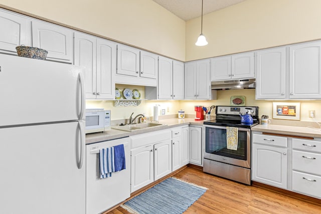 kitchen with white appliances, a sink, under cabinet range hood, and light wood-style flooring