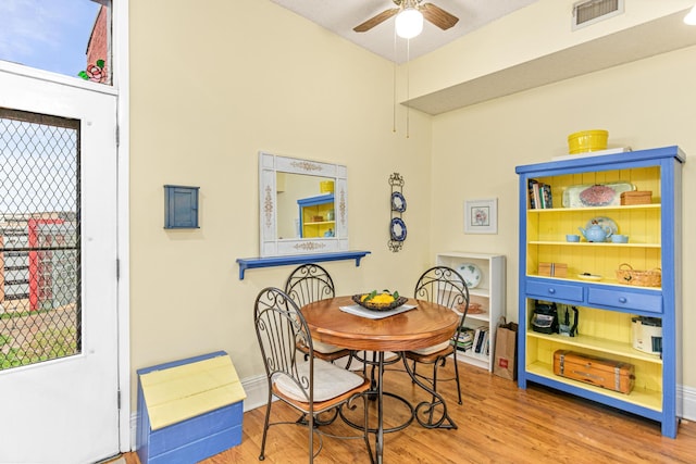 dining area with a ceiling fan, wood finished floors, and baseboards