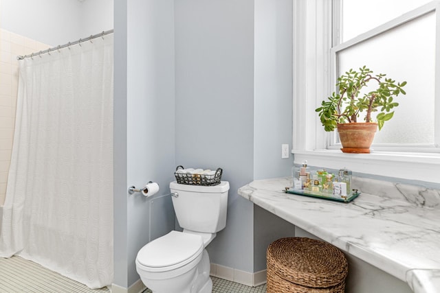 bathroom featuring curtained shower, toilet, tile patterned floors, and baseboards