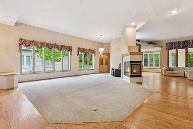 12124 Bluebird Cir NW, Coon Rapids, MN 55448 - unfurnished living room featuring healthy amount of natural light, recessed lighting, baseboards, and a tile fireplace