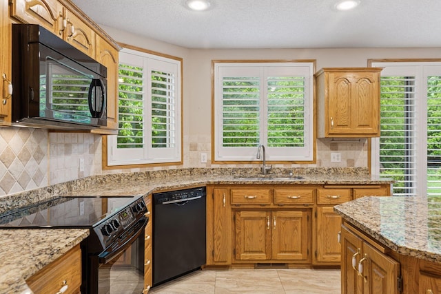 12124 Bluebird Cir NW, Coon Rapids, MN 55448 - kitchen with black appliances, a sink, light stone countertops, tasteful backsplash, and a textured ceiling