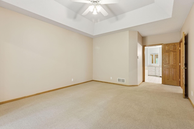 12124 Bluebird Cir NW, Coon Rapids, MN 55448 - spare room with light colored carpet, ceiling fan, a tray ceiling, and baseboards