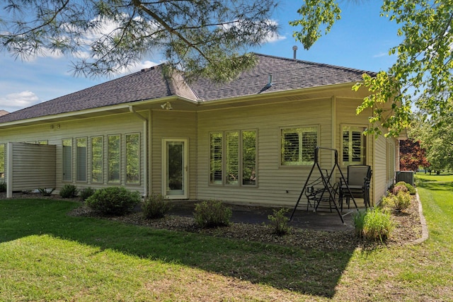 12124 Bluebird Cir NW, Coon Rapids, MN 55448 - back of property featuring a shingled roof, a lawn, and a patio