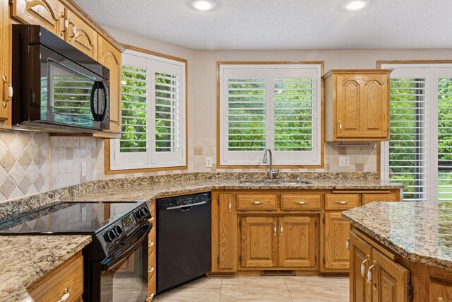 12124 Bluebird Cir NW, Coon Rapids, MN 55448 - kitchen with black appliances, light stone countertops, backsplash, a textured ceiling, and recessed lighting