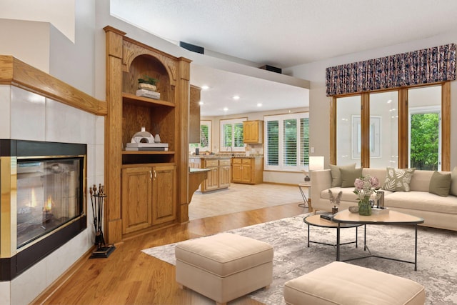12124 Bluebird Cir NW, Coon Rapids, MN 55448 - living room with light wood finished floors, a tile fireplace, and recessed lighting