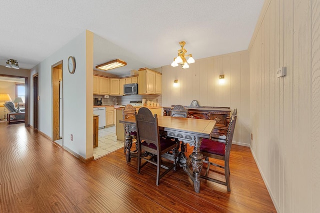 5440 Three Points Blvd Unit 536, Mound, MN 55364 - dining space featuring light wood-style floors, a chandelier, and baseboards