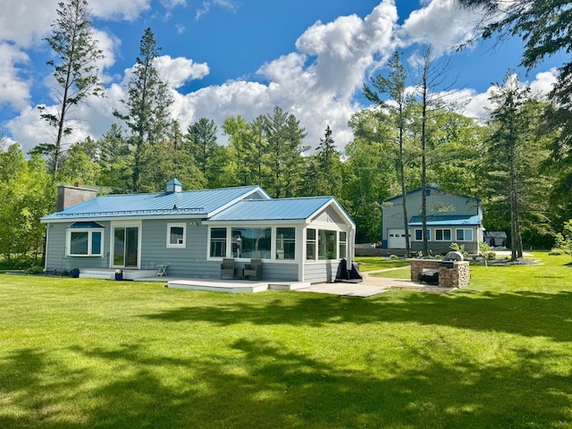 2349 Woodland Shrs, Georgetown Twp, WI 54853 - back of house with a chimney, a patio, a lawn, metal roof, and view of scattered trees