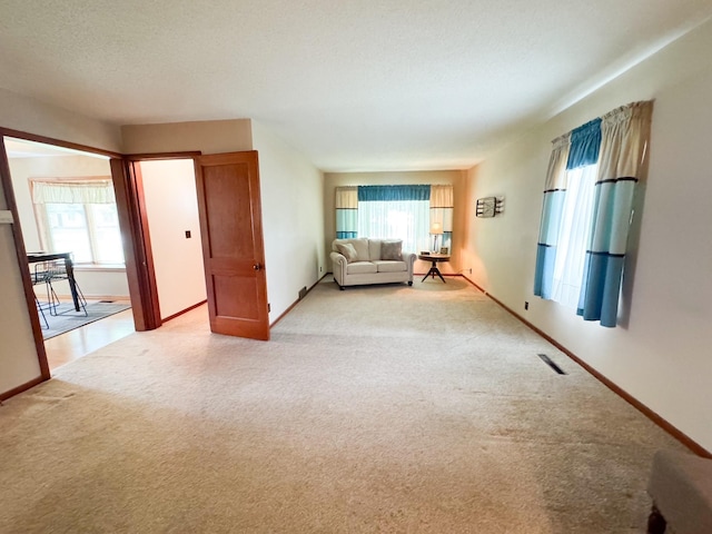 404 5th Ave, Wilmont, MN 56185 - living area with light colored carpet, healthy amount of natural light, and baseboards