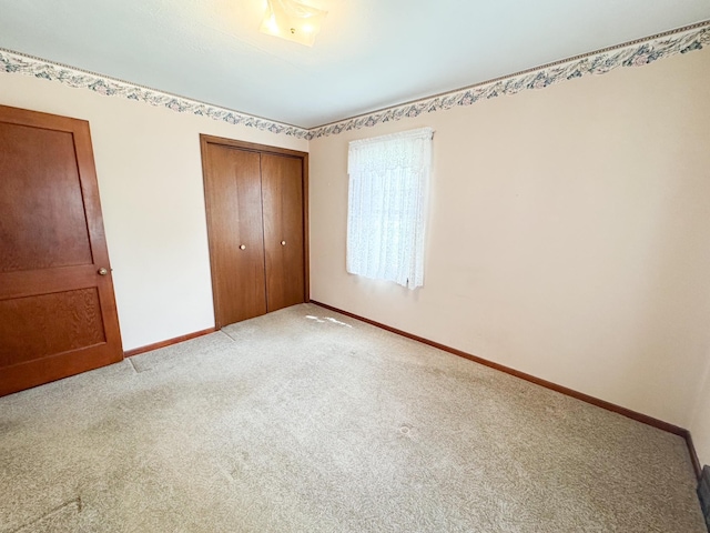 404 5th Ave, Wilmont, MN 56185 - unfurnished bedroom with baseboards, a closet, and light carpet