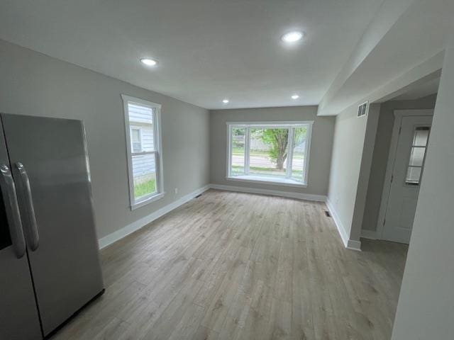 unfurnished living room featuring baseboards, light wood-type flooring, and recessed lighting