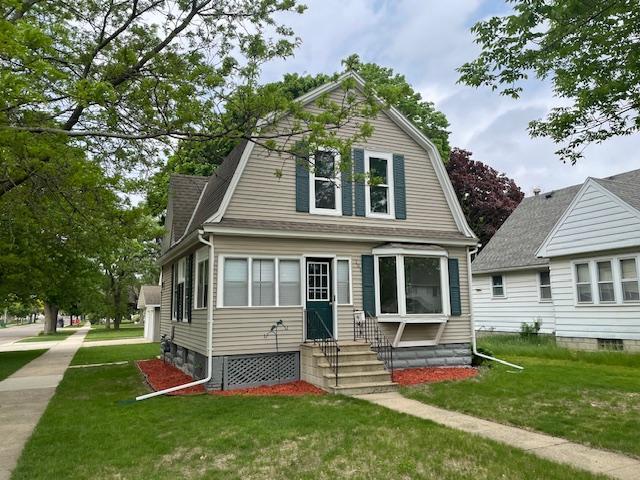 dutch colonial with entry steps, a gambrel roof, a front yard, and roof with shingles