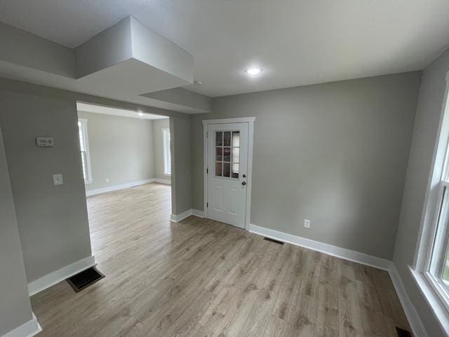 unfurnished room with baseboards, light wood finished floors, and recessed lighting