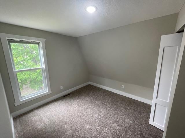spare room with dark colored carpet, baseboards, and recessed lighting