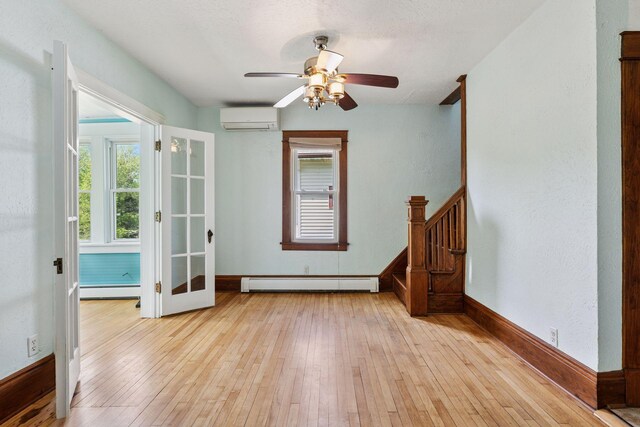 1125 James Ave, Saint Paul, MN 55105 - spare room with a baseboard heating unit, a wall unit AC, light wood-style floors, and a ceiling fan
