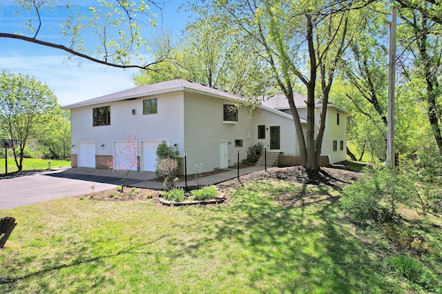 8678 Boiling Springs Ln, Shakopee, MN 55379 - rear view of property featuring asphalt driveway, an attached garage, and a yard