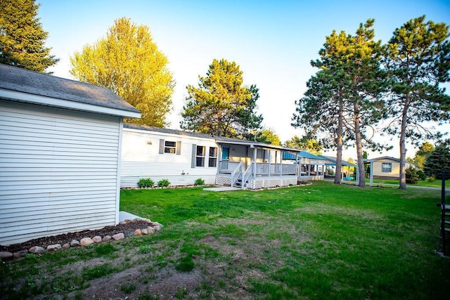 view of green lawn featuring a porch
