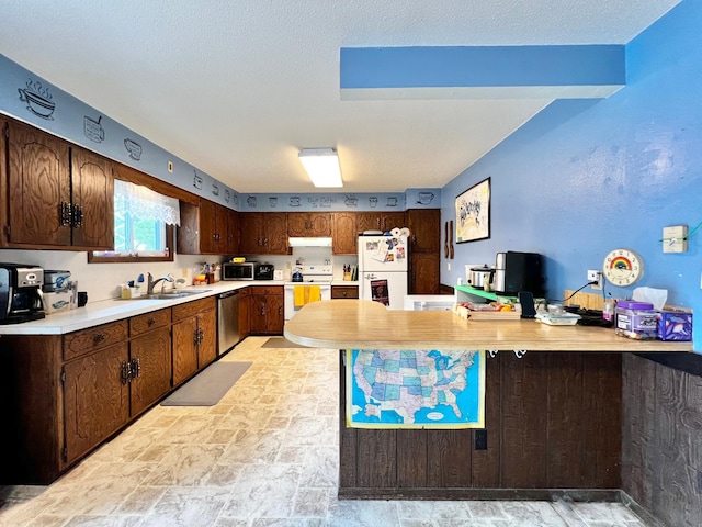 1416 13th Ave, Clarkfield, MN 56223 - kitchen with stainless steel appliances, under cabinet range hood, light countertops, light stone finish floors, and a sink