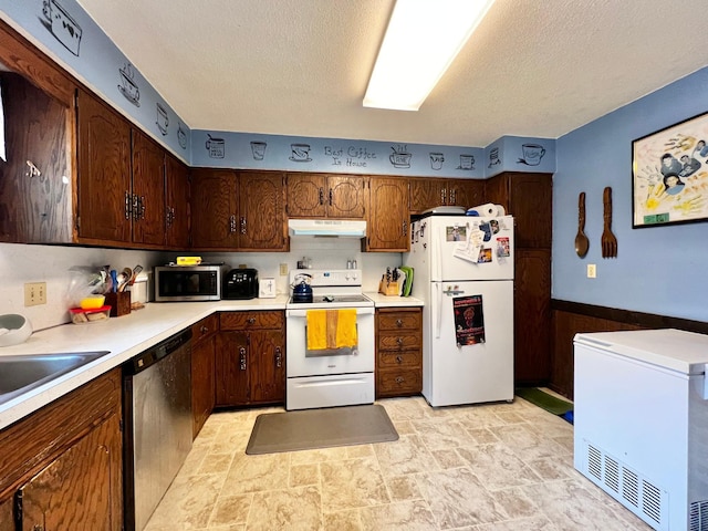 1416 13th Ave, Clarkfield, MN 56223 - kitchen with stainless steel appliances, under cabinet range hood, light stone finish floors, a textured ceiling, and light countertops
