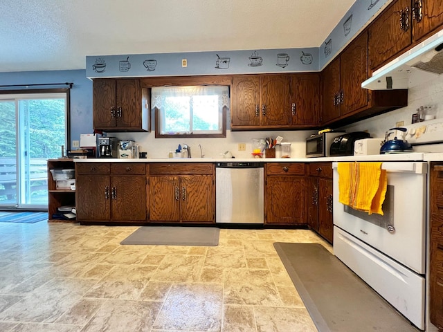1416 13th Ave, Clarkfield, MN 56223 - kitchen featuring stainless steel dishwasher, stone tile floors, under cabinet range hood, and light countertops